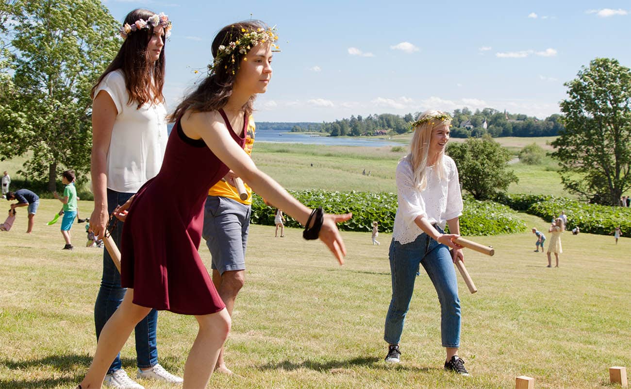 Students playing the traditional Swedish game "Kubb" on Midsummer's Eve